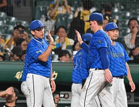 　ハイタッチでナインを迎える三浦監督（左）