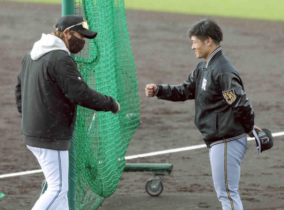 　新庄監督（左）とタッチを交わす坂本（撮影・西岡正）