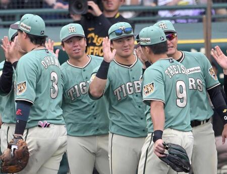 　決勝打を放った立石（９）と勝利のハイタッチを交わす前川（中央）