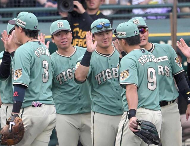 　決勝打を放った立石（９）と勝利のハイタッチを交わす前川（中央）