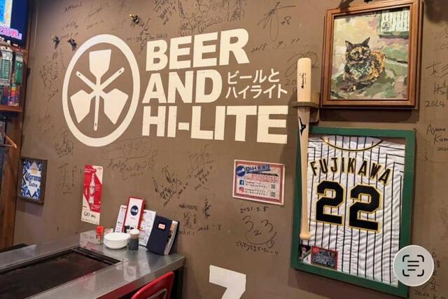　虎党店主・渡辺新一さんが営む「ビールとハイライト」。壁には球児のユニホームが…（撮影は筆者）