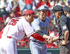 　３日、マツダでの最終戦でメンバー表を交換し、審判団と握手を交わす新井監督（左）と藤川監督