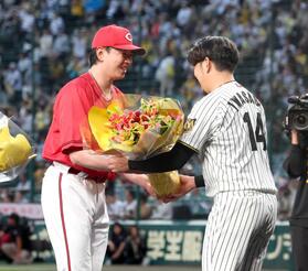 　岩貞（右）の引退セレモニーで花束を手渡す大瀬良（撮影・立川洋一郎）