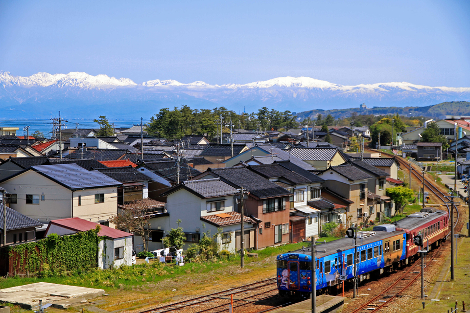 　雄大な雪景色の立山連峰をバックに、ラッピング列車が氷見駅を発車した