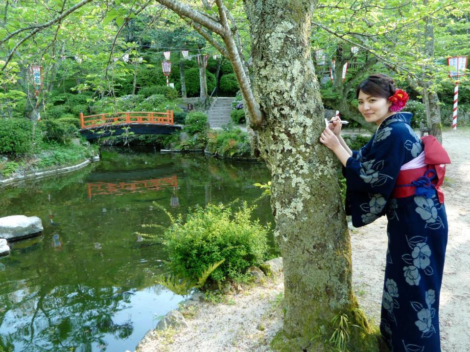 　ミス打吹天女の川畑沙絵さんが「ほどき紙」で悪縁断ち＝倉吉市の打吹公園