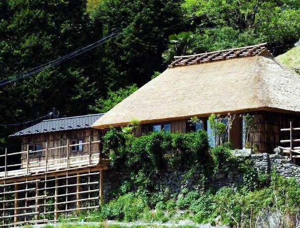 　茅葺き民家「雲外」の外観。左側の建物に浴室とトイレ。廊下でつながっている