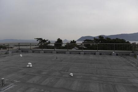 　中学校屋上に上がると島のパノラマが広がる。足元には不思議な作品も（撮影時は準備中）