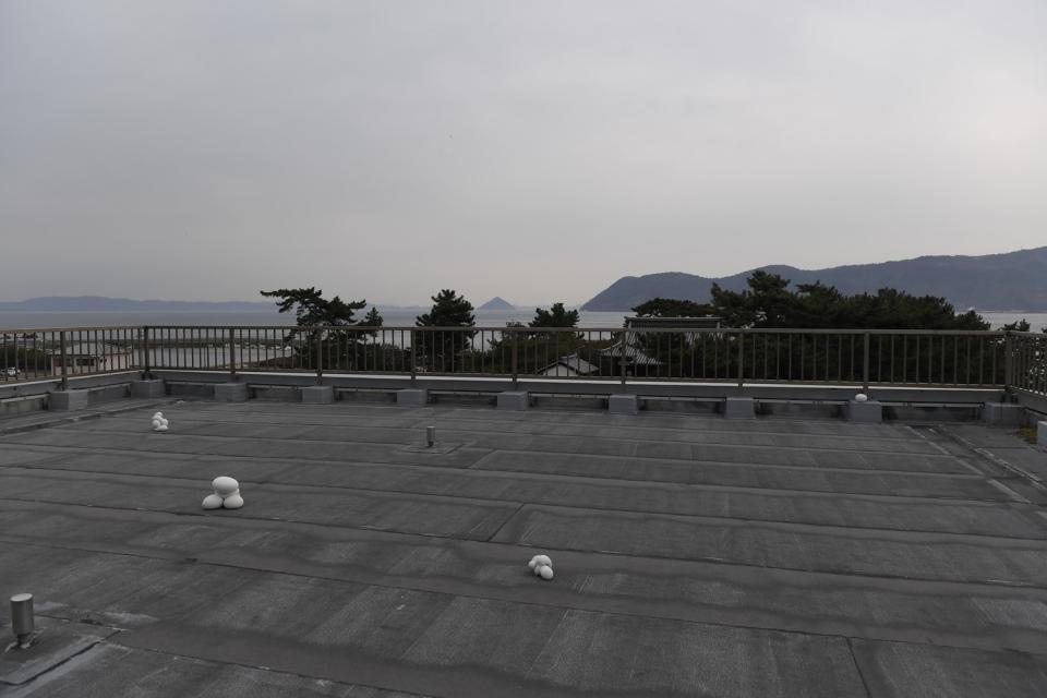 　中学校屋上に上がると島のパノラマが広がる。足元には不思議な作品も（撮影時は準備中）