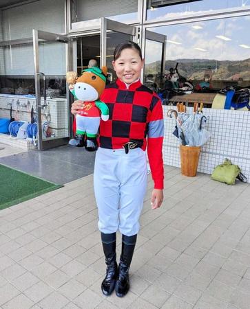 　初勝利記念のターフィー人形を抱き、笑顔を見せる小林美駒