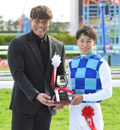 　トロフィーを手に笑顔の横山武（右）とプレゼンターの糸井嘉男氏（撮影・三好信也）