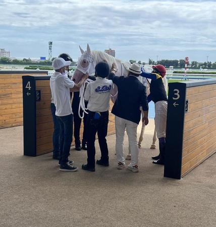 　レースを終えて引き上げてきたカルパと武豊（右）、ねぎらう須貝師（右から２人目）
