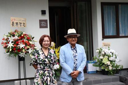 　コテージ「コントレイル」棟の前で記念撮影に応じる矢作師（右）と久子夫人