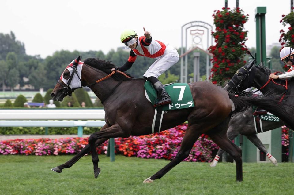 　人気に応えたドゥーラと馬上で人さし指を立てる斎藤