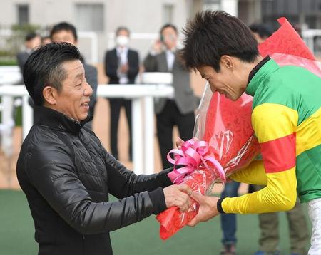 　８Ｒを制した草野に花束を手渡す熊沢（撮影・北村雅宏）
