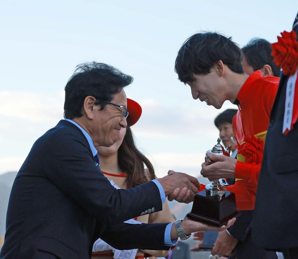 　横山和夫（右）と握手を交わすプレゼンターの栗山英樹氏（撮影・石湯恒介）