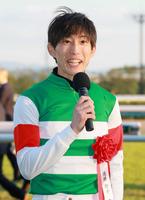 　勝利インタビューで笑顔を見せる藤岡康太さん＝２０２３年１１月１９日、京都競馬場