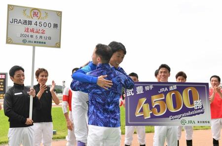 　ＪＲＡ通算４５００勝を達成しプレゼンターのルメールと抱き合う武豊（撮影・佐々木彰尚）