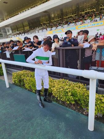 　中京１０Ｒをヒビキで勝利し、ウイナーズサークルでファンにサインする岩田望