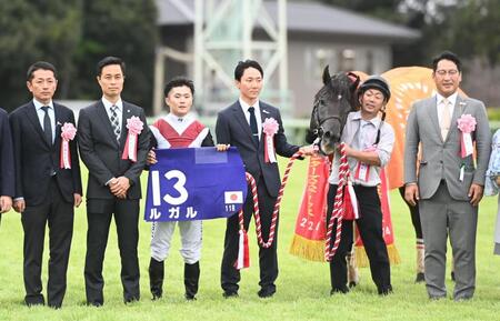 　ルガルと一緒に口取り写真に収まる（左２人目から）杉山晴師、西村淳ら関係者（撮影・園田高夫）