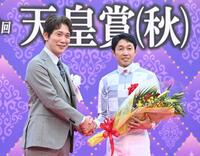 　プレゼンターの佐々木蔵之介（左）と握手をする武豊（撮影・園田高夫）