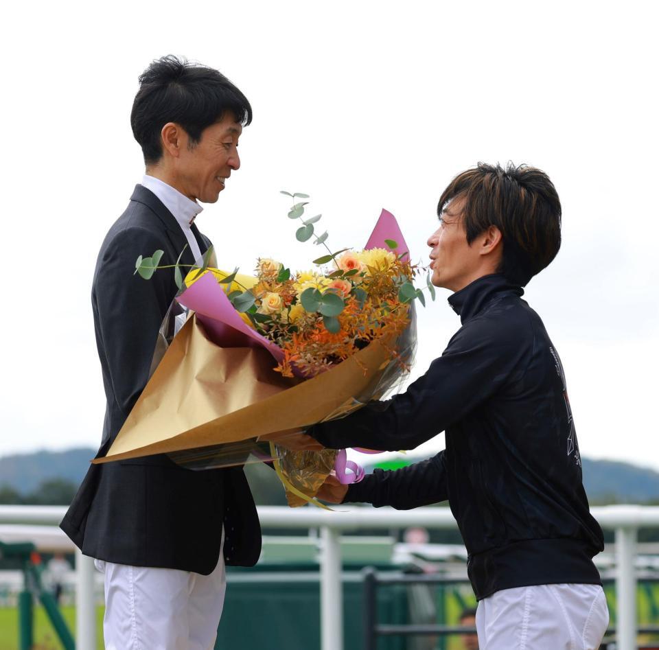 川田（右）から花束を受け取る武豊（撮影・石湯恒介）