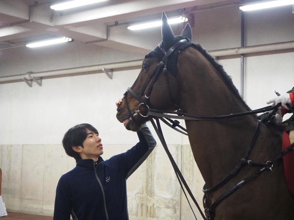 　誘導馬デビューしたアサマノイタズラをなでる嶋田