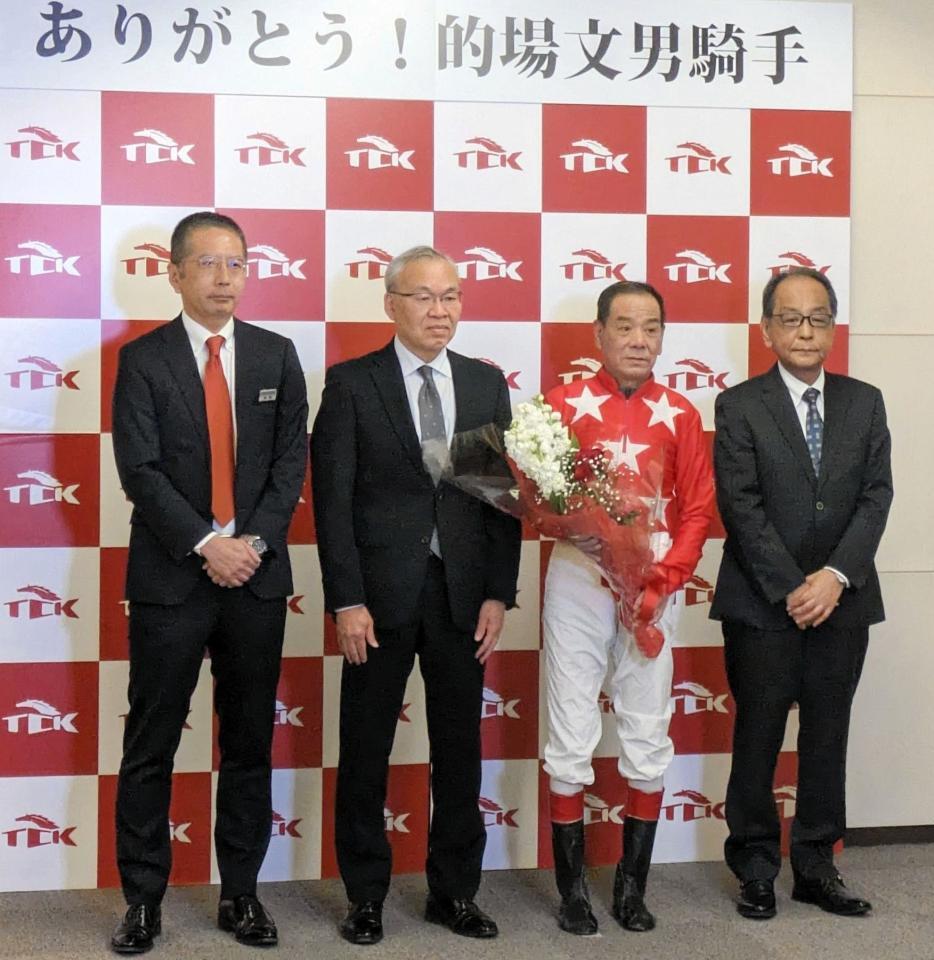 　関係者と記念撮影に収まる的場文（撮影・村上英明）