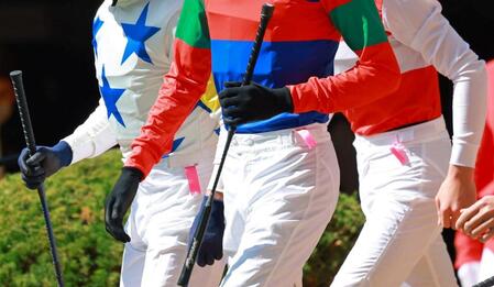 　ピンクのリボンをつけて騎乗に臨む騎手たち（撮影・石湯恒介）