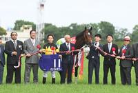 　口取り写真に収まるパンジャタワーと関係者ら（撮影・園田高夫）