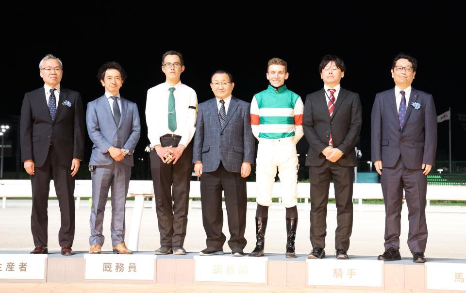 　表彰式で記念写真に納まるデイリースポーツ永井英次常務取締役（右端）と関係者