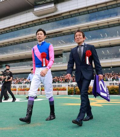 　晴れ晴れと口取りに向かう武豊（左）と石橋師（撮影・石湯恒介）