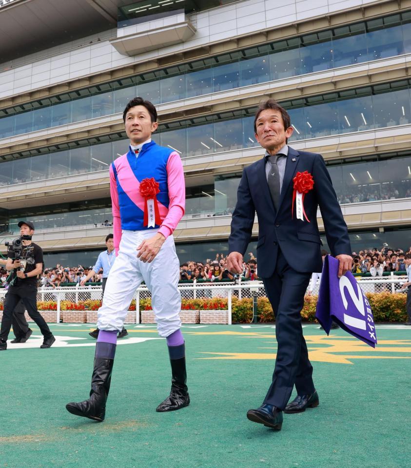 　晴れ晴れと口取りに向かう武豊（左）と石橋師（撮影・石湯恒介）