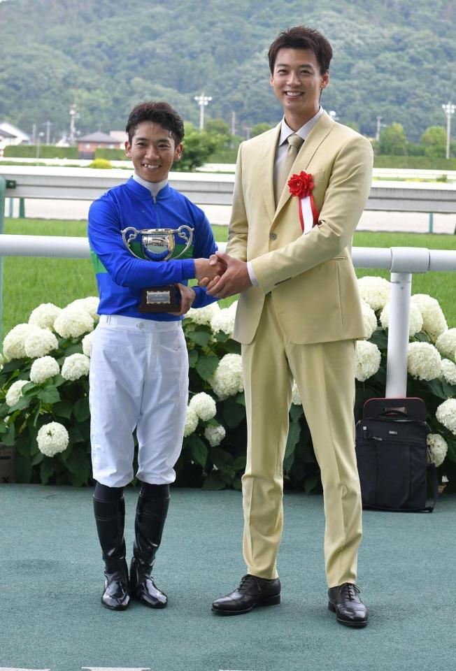 　プレゼンターを務めた竹内涼真（右）と笑顔で握手を交わす荻野極（撮影・持木克友）