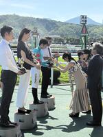 　北九州記念の表彰式プレゼンターを務めた桜井日奈子からトロフィーを渡される団野大成