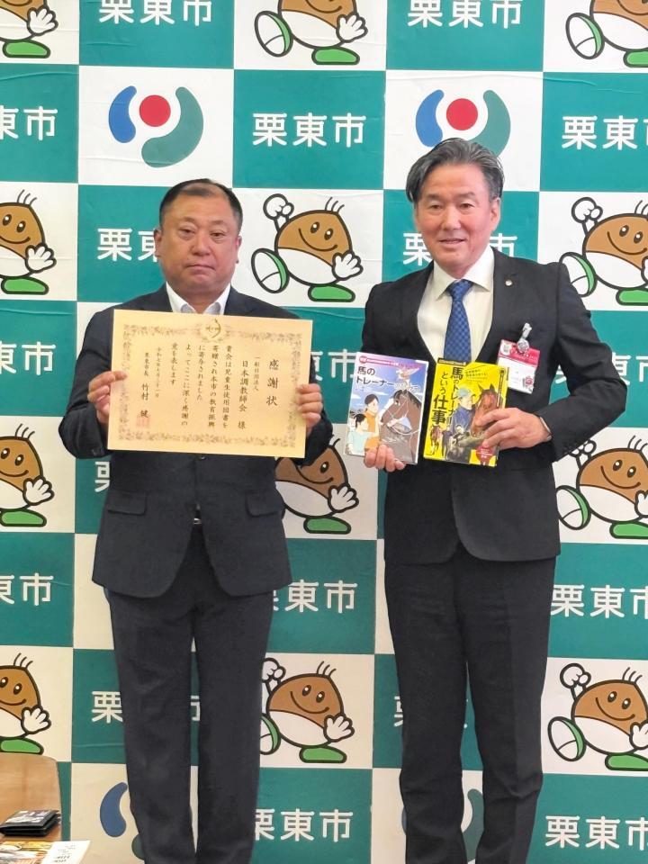 　図書寄贈式に出席した高橋義忠調教師（左）と栗東市・竹村健市長
