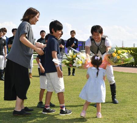 　７Ｒでの最終騎乗を終え家族から花束をもらい笑顔の宮崎北斗（撮影・持木克友）
