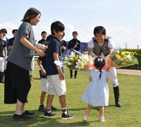 　７Ｒでの最終騎乗を終え家族から花束をもらい笑顔の宮崎北斗（撮影・持木克友）