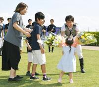 　最終騎乗を終え、家族から花束を贈られ笑顔を見せる宮崎北斗（撮影・持木克友）
