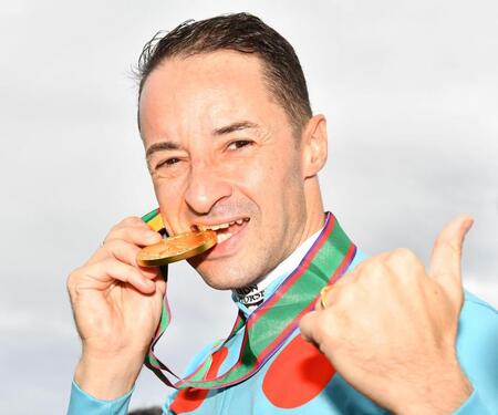 　秋華賞を制し、メダルをかみながらサムアップポーズを見せるルメール（撮影・中田匡峻）