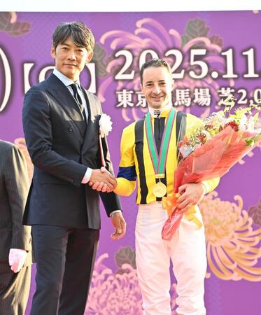 　天皇賞を制しプレゼンターの反町隆史（左）と笑顔で握手を交わすＣ・ルメール（撮影・持木克友）