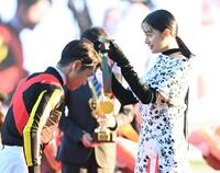 　エリザベス女王杯を制したレガレイラの戸崎圭（左）にメダルをかける山本美月