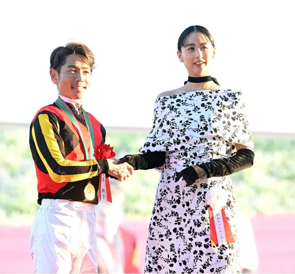 　握手を交わす戸崎圭（左）と山本美月（撮影・飯室逸平）