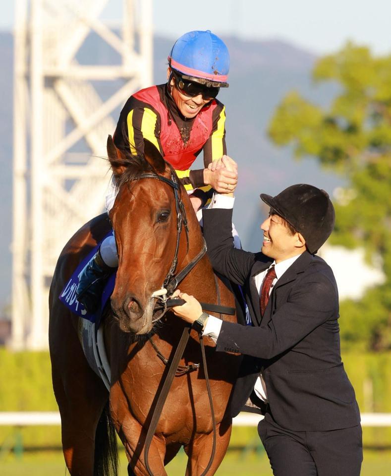 　担当者と握手を交わす戸崎圭（撮影・石湯恒介）