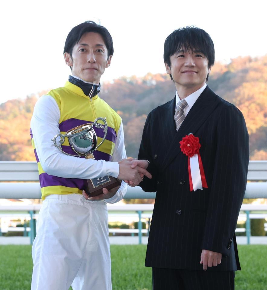 　ニシノティアモで福島記念を制し、プレゼンターの風間俊介と握手する津村（左）