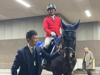 　今年最後の仕事を終えた誘導馬のカラテをなでる小田切光オーナー