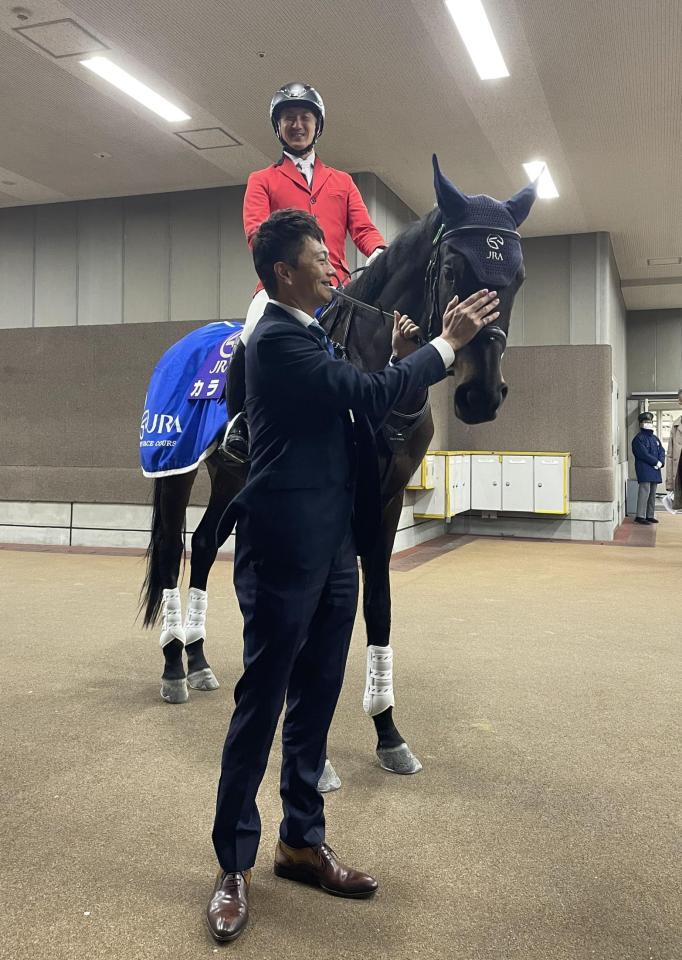 　今年最後の仕事を終えた誘導馬のカラテをなでる小田切光オーナー