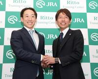 　調教師試験に合格し、笑顔で握手を交わす藤岡佑（左）と和田竜（撮影・中田匡峻）