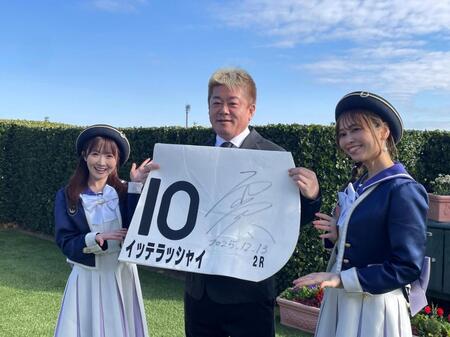 　中山２Ｒを勝利したイッテラッシャイのゼッケンを持って笑顔を見せる堀江貴文氏（中央）とウィナーズレディら
