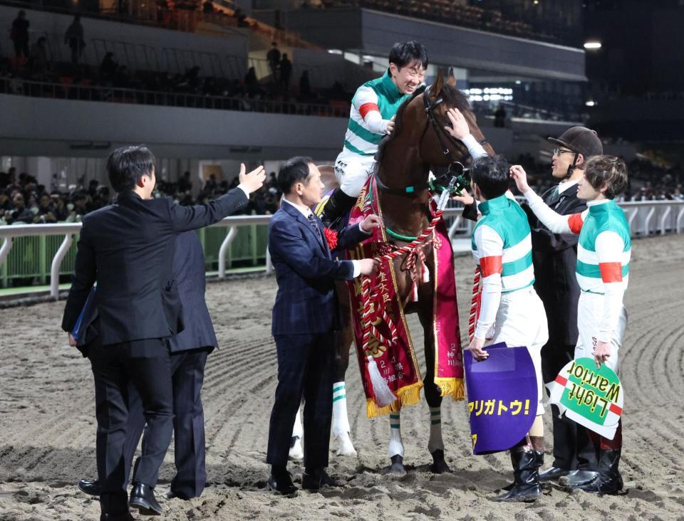 　吉原寛ら騎手から頭をなでられるライトウォーリア