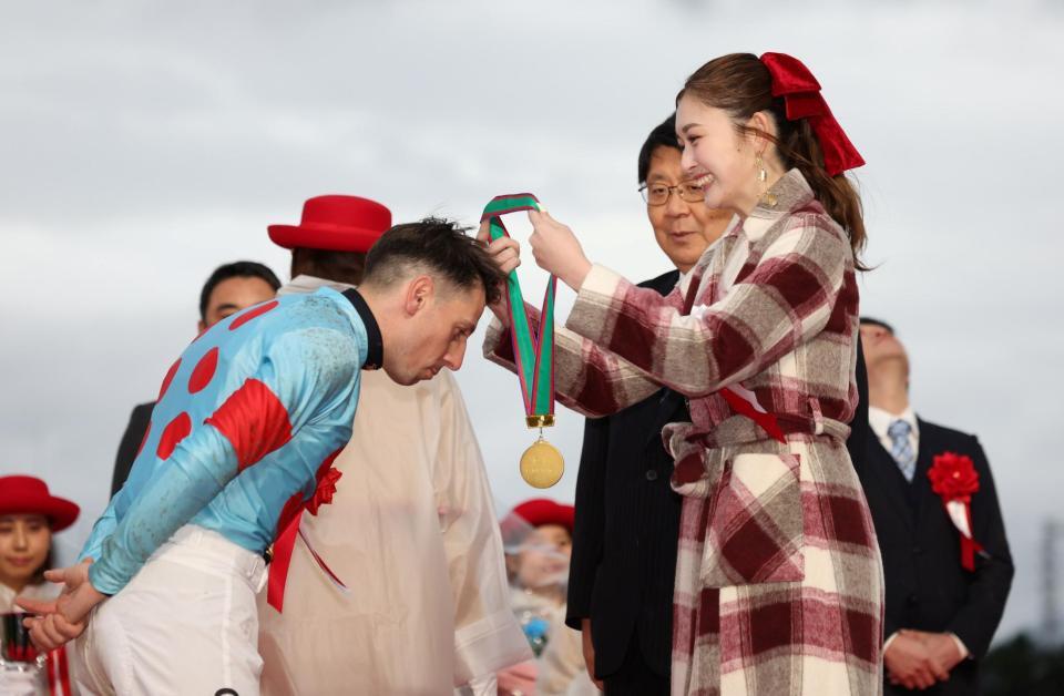 　１１Ｒ、朝日杯をカヴァレリッツォで制したクリスチャン・デムーロ（左）にメダルをかけるプレゼンターのゆうちゃみ（撮影・中田匡峻）